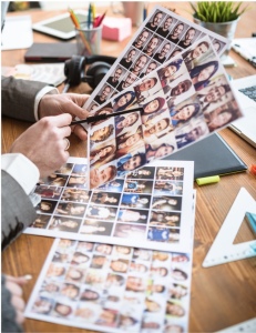 Des mains tiennent des planches de photos d'identité